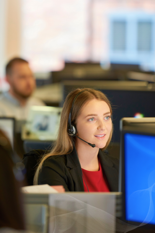 Young person working in a call centre sitting at their desk. 