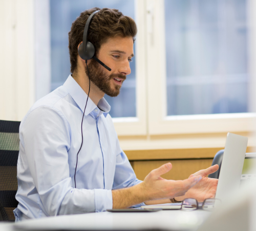 man with headset talking to laptop screen